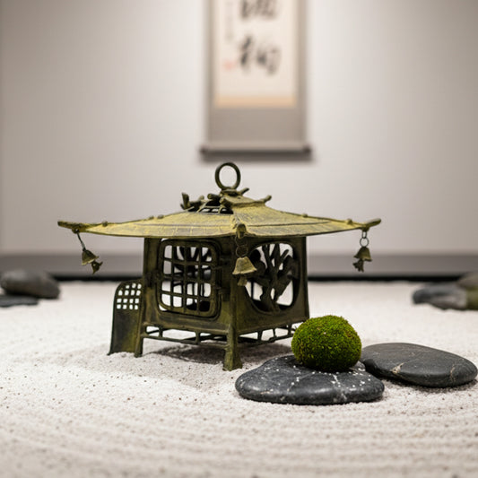 Lámpara japonesa de pescador en un jardín Zen de arena blanca con piedras y musgo, presentada por Tenkei Gallery.