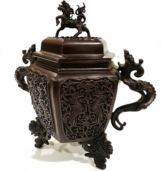 Detalle de los grabados y texturas de figuras mitológicas en el cuerpo de un incensario Takaoka.