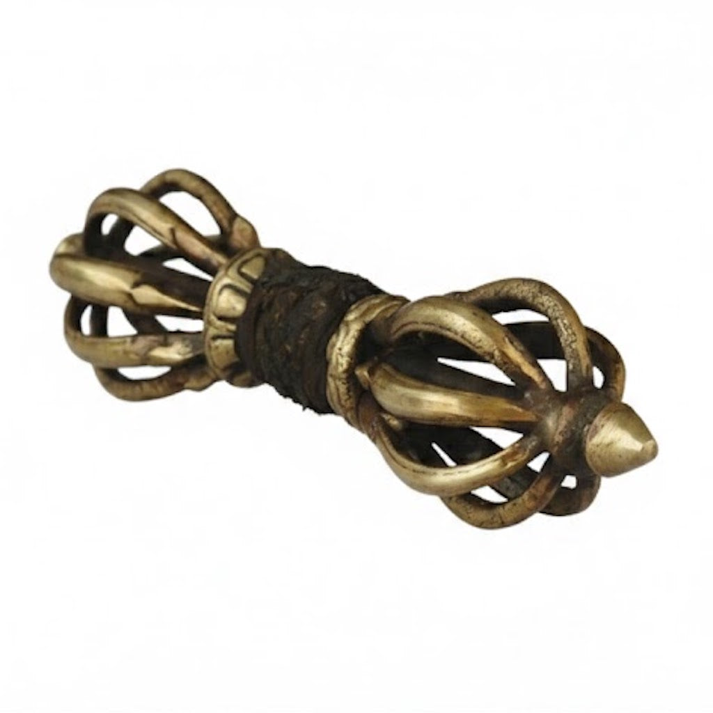 Vajra o Dorje ritual de bronce fabricado artesanalmente en Nepal con pátina antigua sobre fondo blanco.